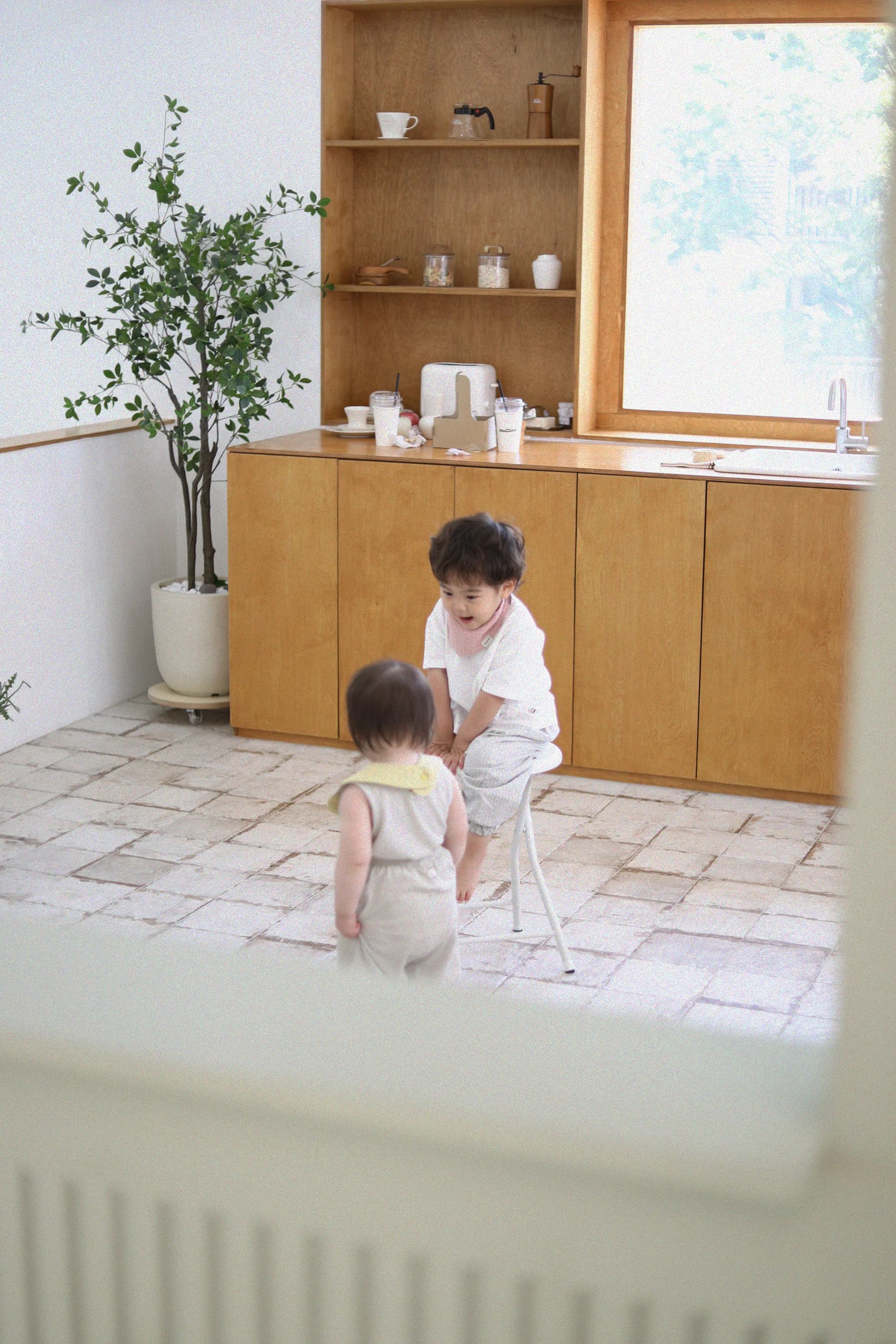 아모리 거즈 스카프 빕 착용 아기 남매 주방 놀이 장면